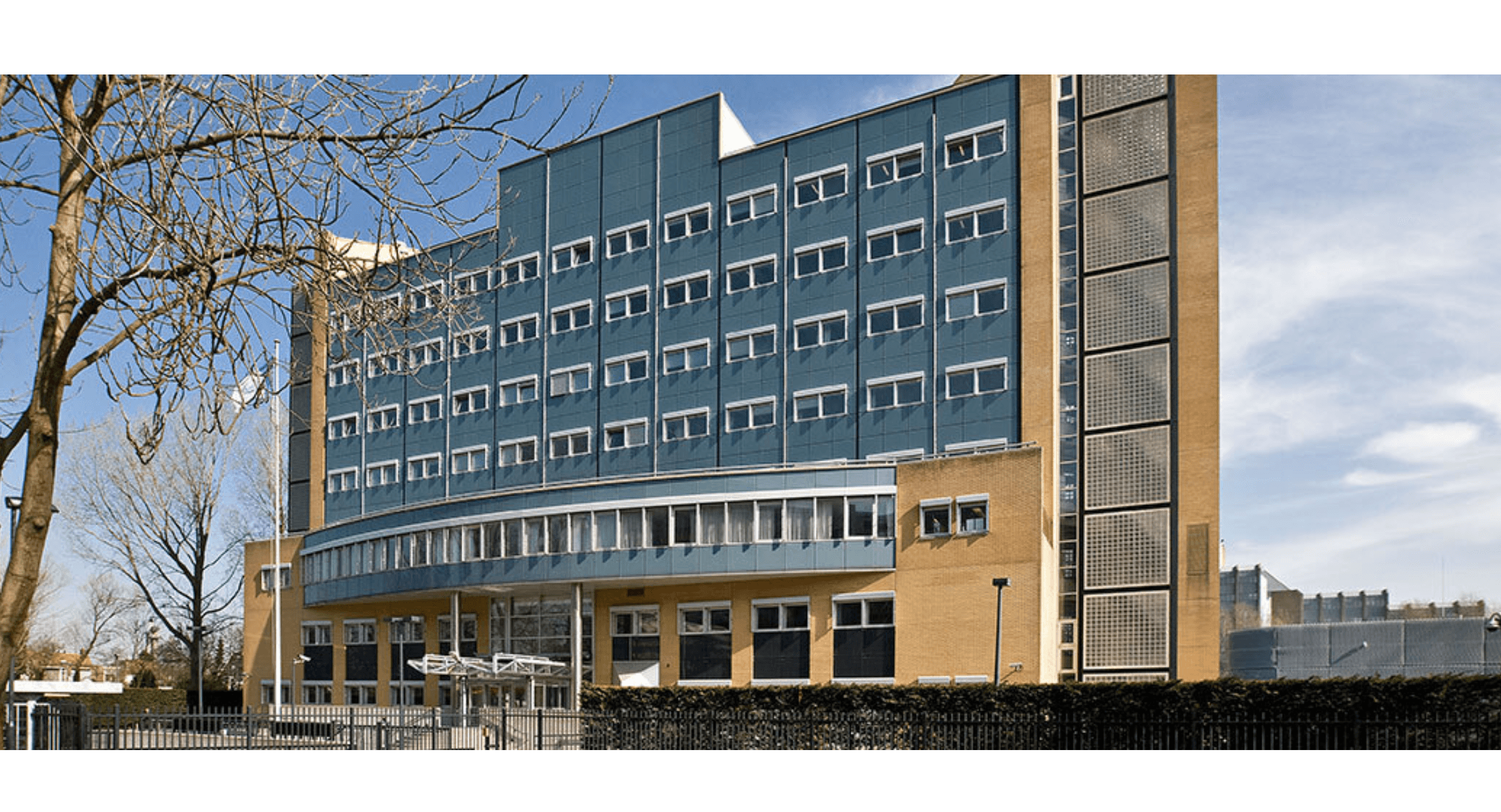 Building with many windows with blue and orange colors, with a small tree out front. Building housed the Special Tribunal for Lebanon.