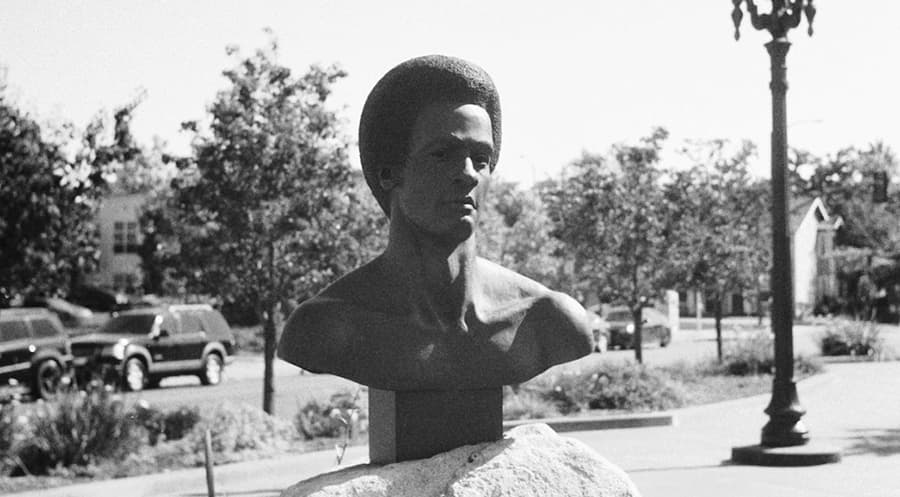 An outdoor sculpture mounted on large decorative rock.