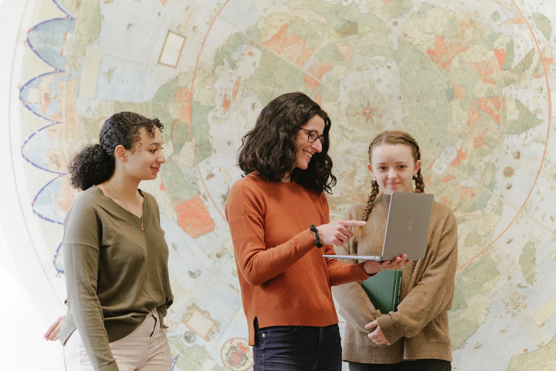Librarian and students work on laptop in the Hohbach Hall study area